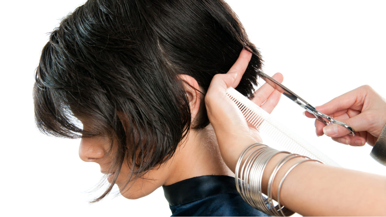 peluquero cortando el cabello de una mujer